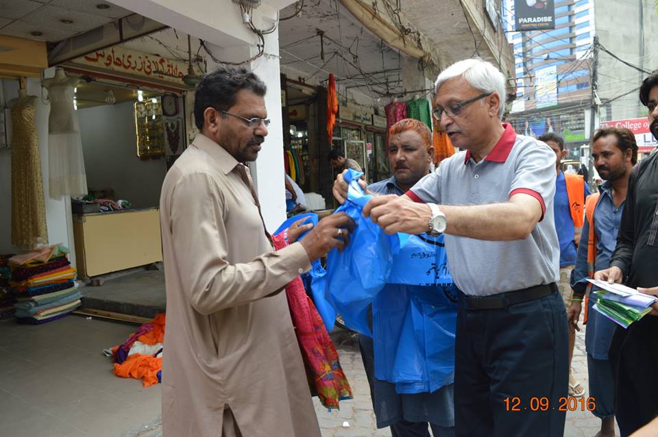 MD GWMC Dr Atta-ul-Haq distributing waste Bags in General public