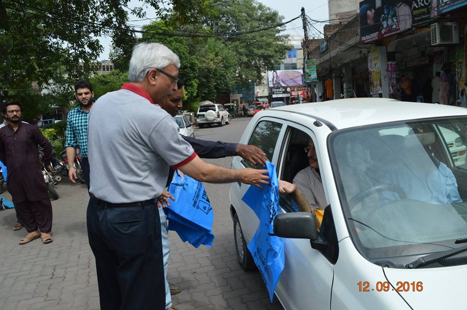 MD GWMC Dr Atta-ul-Haq distributing waste Bags in General public