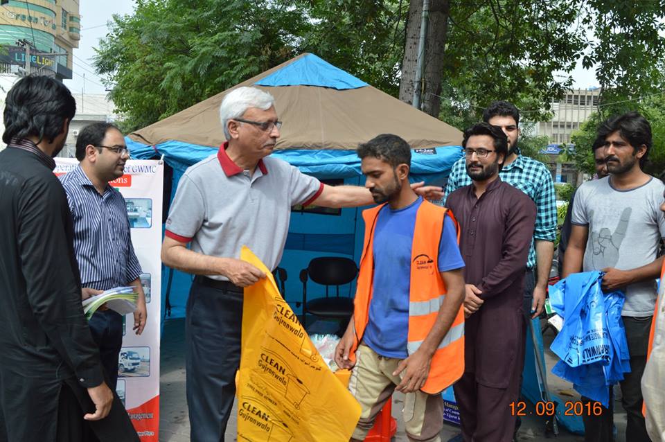 MD GWMC Dr Atta-ul-Haq distributing waste Bags in General public